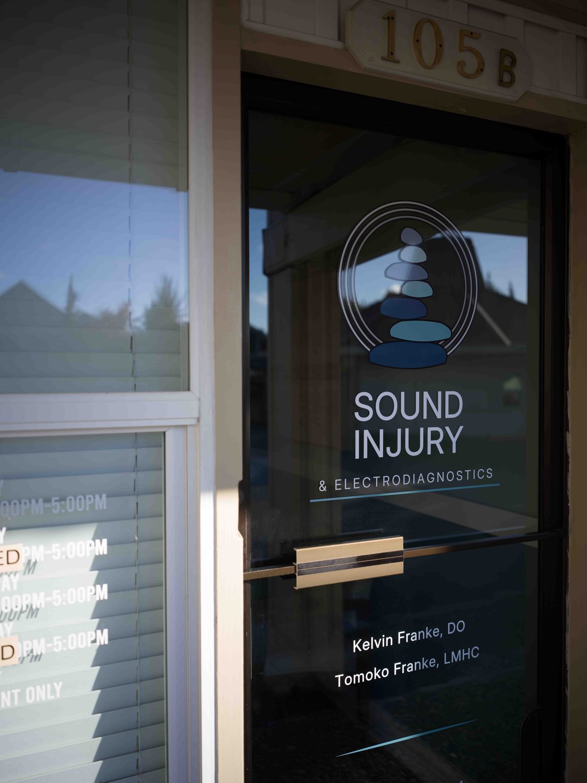 The Edmonds entrance: a glass door marked 105B with the Sound Injury cairn logo, Kelvin Franke DO and Tomoko Franke LMHC, and the opening hours on the window beside it