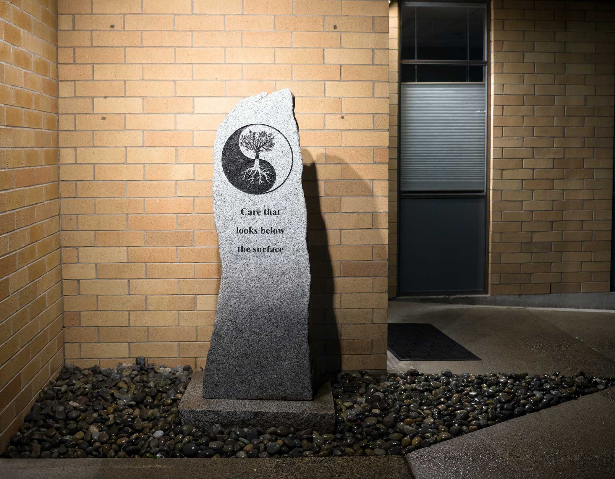 Stone monument with 'Care that looks below the surface' inscription